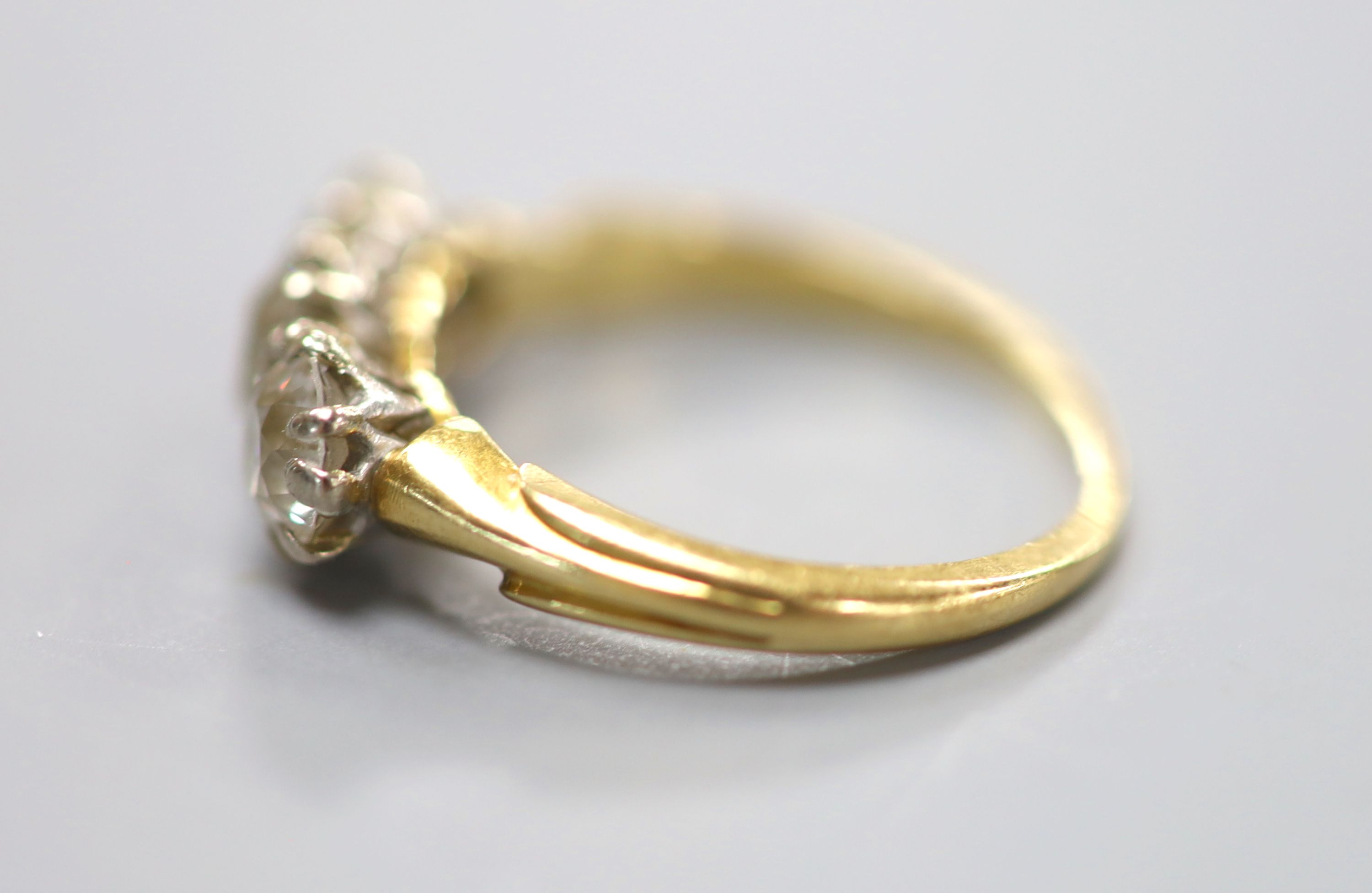 A yellow metal and three stone diamond ring, size L, gross weight 3.3 grams